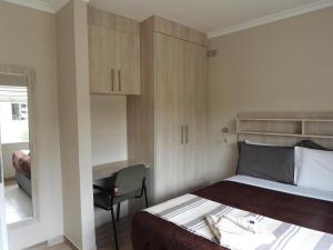 哈拉雷2 bedroomed apartment with en-suite and kitchenette - 2071的一间小卧室,配有一张床和一张书桌