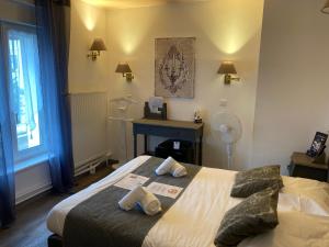 GrandvillersHotel L'Ecrin 88 Vosges的一间卧室配有一张带两个枕头的床和一张书桌