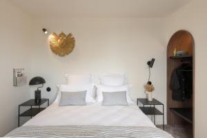 帕雷·勒·毛尼尔Hôtel Le Prieuré的卧室配有一张带白色床单和枕头的大床。
