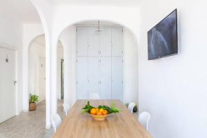 蓬扎~ ~ Brezza Mediterranea ~ ~的一间用餐室,配有一张带一碗橙子的木桌