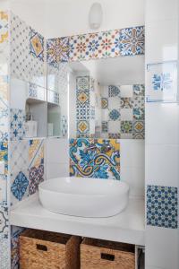 蓬扎~ ~ Brezza Mediterranea ~ ~的浴室铺有蓝色和白色瓷砖,配有水槽