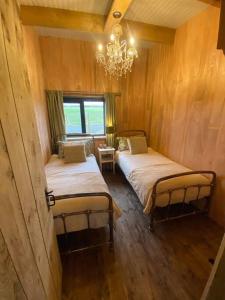 兰卡斯特The CowShed Cottage - Beautiful Location的配有吊灯的客房内的两张床