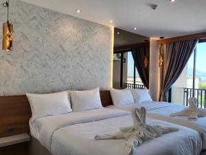 华欣S3 Huahin Hotel的两张位于酒店客房的床,配有毛巾