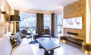 萨尔巴赫AvenidA Mountain Lodges Saalbach的带沙发和电视的客厅