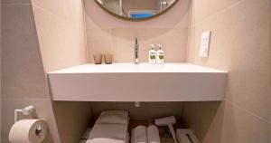 劳拉斯玛LaSpa Beach House的浴室设有白色水槽和镜子