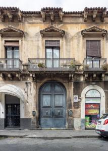 卡塔尼亚Catania City Center Historical Building Home的一座带蓝色门和阳台的建筑