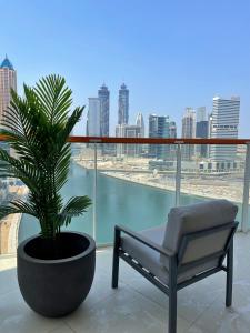 Al ḨamīdīyahDubai Canal Burj khalifa view 2bedroom apartment的美景阳台的椅子和植物