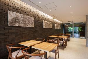京都Gion Elite Terrace的餐厅设有木桌和椅子,靠砖墙