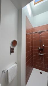 旺德尔港莱斯帕格博酒店及餐厅的浴室设有棕色瓷砖和淋浴。