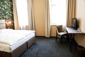 布拉格EA Hotel Victoria的配有一张床、一张书桌和一扇窗户的酒店客房
