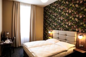 布拉格EA Hotel Victoria的卧室配有一张位于床上方的大型花卉墙