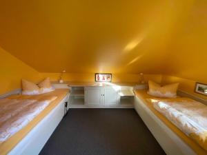 巴德贝芬森Appartementhaus Grieger的黄色墙壁客房的两张床