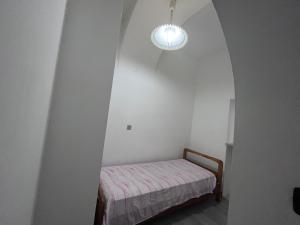 罗迪-加尔加尼科Casa vacanze la volta的小房间设有一张床和一个吊灯