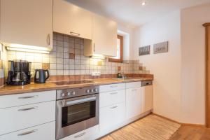 基茨比厄尔Apartments Foidl的厨房配有白色橱柜和炉灶烤箱。