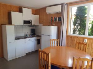福纽德Fonyód Camping & Apartman的厨房配有白色家电和木桌