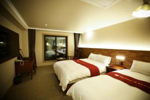大邱Ariana Hotel的酒店客房设有两张床和电视。