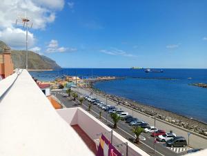 San AndrésApartamento en primera línea de mar, las Teresitas, Santa Cruz de Tenerife的海港景色,停泊在水边的汽车
