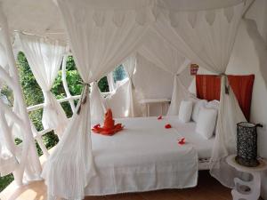 布桑加AL FARO Cosmio Hotel Palawan的卧室配有白色的白色床和白色的窗帘