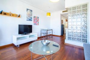 马德里卡斯蒂拉卢德科公寓的客厅配有玻璃桌和电视