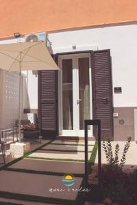 玛格丽塔萨沃亚Mare & Relax的房屋设有带雨伞和桌子的庭院