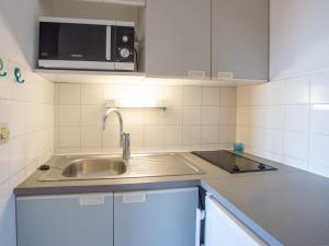 勒拉旺杜Apartment Saint James-9 by Interhome的厨房配有水槽和微波炉