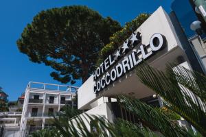 瓦拉泽Coccodrillo Hotel & Apartments的大楼前的酒店标志