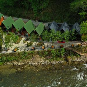 贾马里海姆森Tanura Bungalows的河边的绿色屋顶建筑