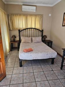 波罗瓜尼Motel Villa Africa的一张位于带两张桌子和窗户的房间的床位