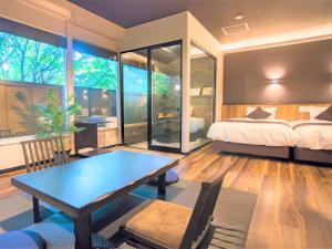 箱根LiVEMAX RESORT Hakone Ashinoko的一间卧室配有一张床、一张桌子和一张床