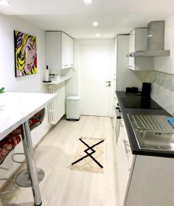 泰昂维Superbe studio privé的厨房配有白色橱柜和黑色台面