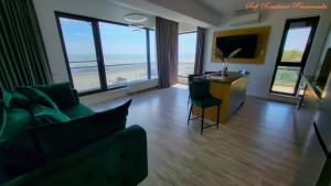 北马马亚-讷沃达里Sofi Residence Promenada的带沙发和电视的客厅以及海滩