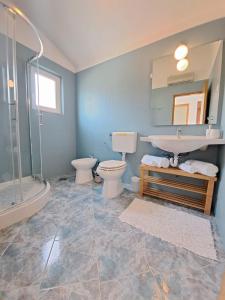 罗加克Villa Porto的浴室设有2个卫生间、水槽和淋浴。