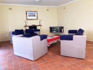 KhemsbokKalahari Homestead的客厅配有2把白色椅子和桌子