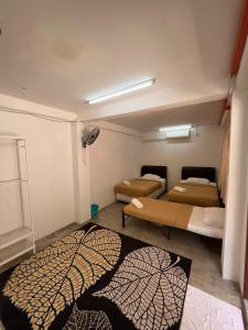 太平MyDusun Chalet, Taiping, Perak, Malaysia的一间设有两张床的客房,地板上铺有地毯。