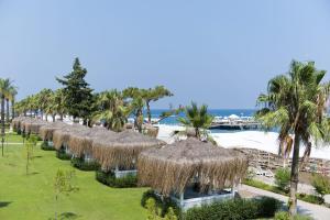 安塔利亚MIRADA DEL MAR HOTEL的海滩上的一排草伞