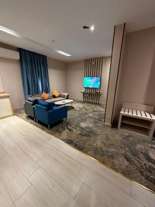 泰布克Banan Hotel Suites的客厅配有蓝色的沙发和电视