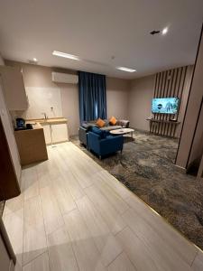 泰布克Banan Hotel Suites的一间带蓝色沙发的客厅和一间厨房