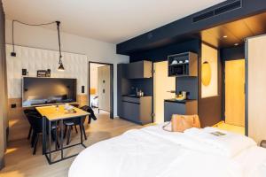 斯普赖滕巴赫harry's home Zürich-Limmattal的一间卧室配有一张床铺和一张桌子,还设有一间厨房