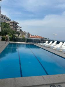 库萨达斯斯特拉酒店的大型蓝色游泳池配有白色躺椅