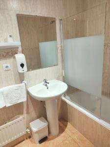 哈卡Hotel Acebo Plaza Mayor的浴室配有盥洗盆、镜子和浴缸