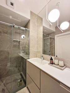 辛安诺泽蒂Gea Eco Apartament 206的一间带水槽和玻璃淋浴的浴室