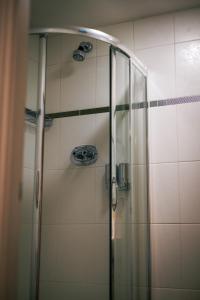 Coxhoe老磨房旅馆的浴室里设有玻璃门淋浴