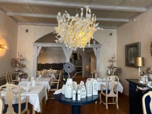 施特拉尔松德豪斯沃弗卡纳酒店的一间设有白色桌子和吊灯的用餐室