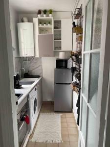 巴黎Charmant appartement cosy 2 pièces Paris 15e的小厨房配有白色橱柜、洗衣机和烘干机