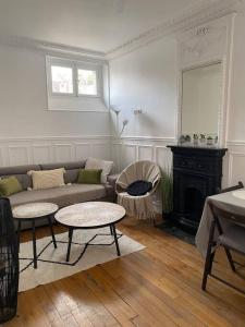 巴黎Charmant appartement cosy 2 pièces Paris 15e的客厅配有沙发、桌子和壁炉