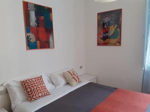 里米尼Hotel Migani的卧室配有白色沙发,墙上挂有两幅画作