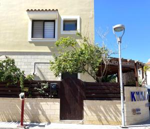 帕拉利米尼Kyklades Resort & Spa的一座带木栅栏和街灯的房子