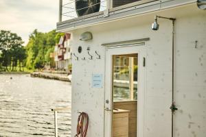 法尔松Farsund Resort的白色的建筑,有一扇门,紧靠水体