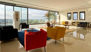阿加迪尔TigMAÏA Guest House In Agadir for Traditional Art and Culture的客房设有桌椅和大窗户。