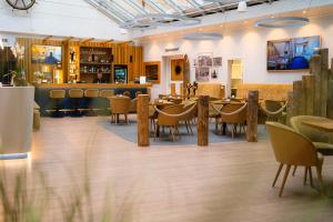 瓦尔内明德阿尔滕斯特罗姆酒店的一间带桌椅的餐厅和一间酒吧